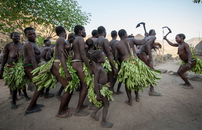 Young women wrapped in leaves; Source: Democracy Newsline